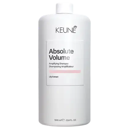 Frasco branco da linha Absolute Volume da Keune, contendo shampoo amplificador. Rótulo com o nome da marca e do produto, além de informações sobre o extrato de lírio como ingrediente.