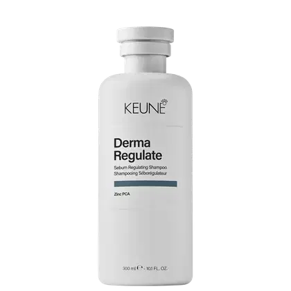Frasco branco de shampoo Keune Derma Regulate, com rótulo preto e cinza indicando o nome do produto e seu uso para regular a oleosidade do couro cabeludo. Embalagem cilíndrica com tampa branca.