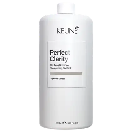 Frasco branco da linha Keune Perfect Clarity, contendo shampoo clarificante com extrato de capucine. Rótulo com nome do produto e informações sobre o conteúdo de 1000 ml.