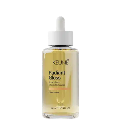 Frasco de vidro transparente com conta-gotas branco contendo um líquido dourado. Rótulo com o nome "Keune Radiant Gloss" e informações sobre o produto, como "Illume Infusion" e "Orchid Extract".