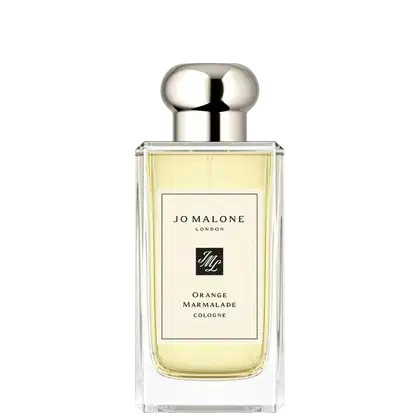 Frasco de vidro transparente com tampa prateada em formato arredondado. Rótulo branco com texto "Jo Malone London" e "Orange Marmalade Cologne". Produto de perfumaria em tom amarelo claro.
