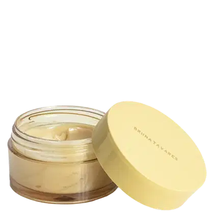 Recipiente de vidro transparente com tampa amarela, contendo um produto de perfumaria. O recipiente possui uma etiqueta com o texto "BRUNATAVARRES" em letras brancas sobre fundo amarelo.