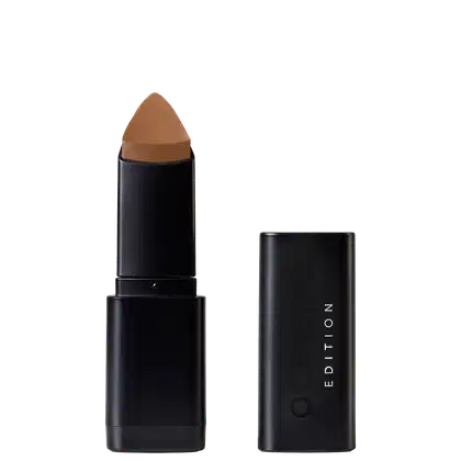 Corretivo em Bastão Océane Concealer Stick. Possui tampa preta e corpo cilíndrico preto liso. Na embalagem, há o texto "EDITION" em letras brancas.