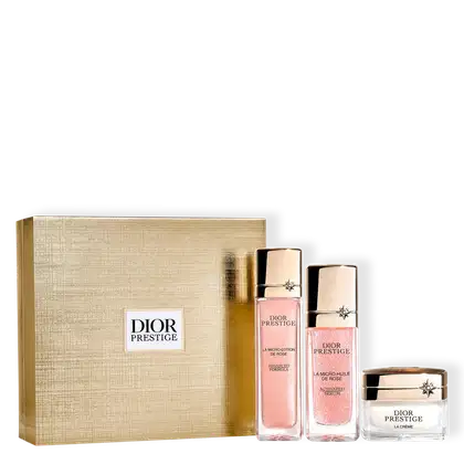Conjunto de produtos de beleza da marca Dior Prestige, incluindo uma loção, um sérum ativado e um creme em embalagens com detalhes em dourado e rosa. A caixa de presente em tom bege completa o conjunto.