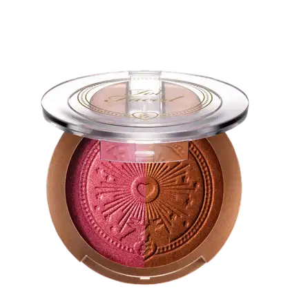 Pó bronzeador compacto em embalagem redonda de plástico transparente, com detalhes dourados e um desenho de sol estampado no centro. O produto possui uma tonalidade dourada brilhante.