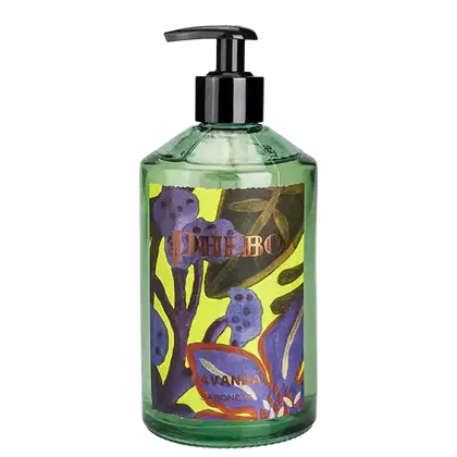 Frasco da marca Phebo com design colorido de flores e folhas, com bomba doseadora preta, posicionado sobre folhagem verde.