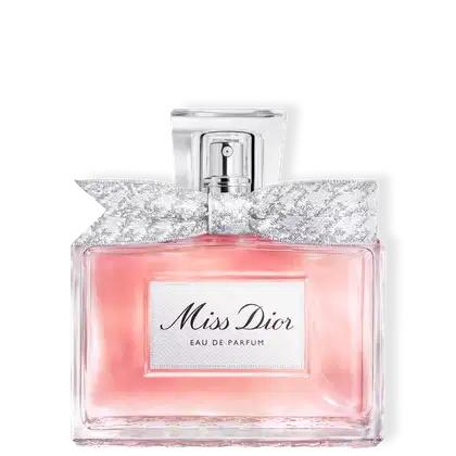 Frasco de perfume Miss Dior em formato retangular com tampa prateada. Embalagem com detalhes em renda branca e rosa claro, com texto "Miss Dior Eau de Parfum" em destaque.