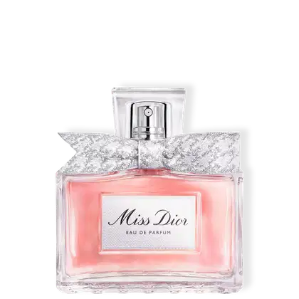 Frasco de perfume Miss Dior em formato retangular com tampa prateada. Embalagem com detalhes em renda branca e rosa claro, com texto "Miss Dior Eau de Parfum" em destaque.