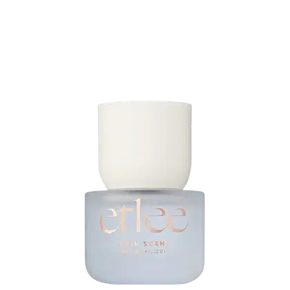 Frasco de perfume Etleé Skin Scent em embalagem branca com texto em dourado. O frasco possui formato cilíndrico e tampa arredondada, com o nome da marca e a descrição "Eau de Parfum" visíveis.