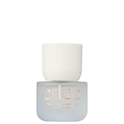 Frasco de perfume Etleé com tons de cinza e branco, contendo a descrição "Toasted Vanilla Eau de Parfum" em letras douradas. O frasco possui uma tampa branca.