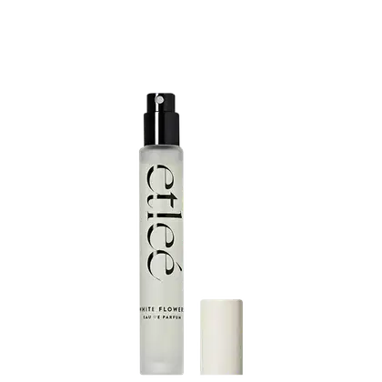 Frasco de perfume Etleé White Flower Eau de Parfum em embalagem transparente, com borrifador preto e com texto em preto destacando o nome da fragrância.