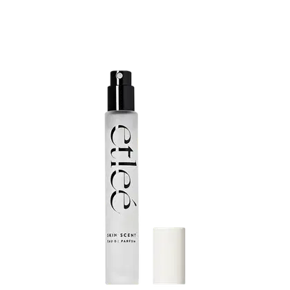 Frasco de perfume Etleé Skin Scent em embalagem branca e preta, com texto destacado em preto. O produto é apresentado com aplicador preto e tampa branca ao lado