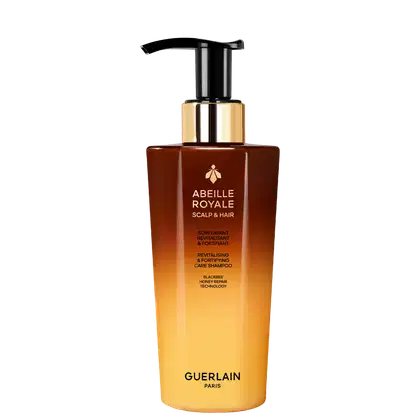Frasco de shampoo Abeille Royale da Guerlain, com design elegante em tons de marrom e dourado, contendo tecnologia de reparo de mel de abelha para revitalizar e fortalecer o couro cabeludo e os cabelos.