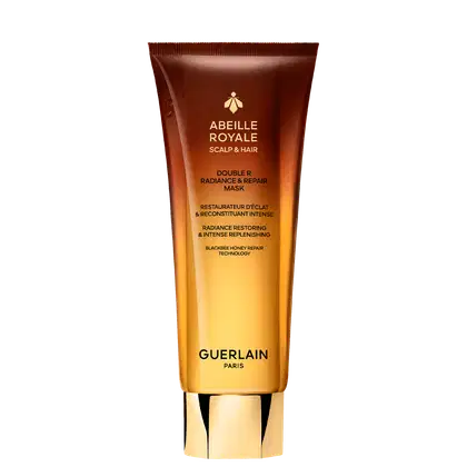 Tubo de máscara capilar da linha Abeille Royale da Guerlain, com embalagem em tons de laranja e marrom, destacando a tecnologia de reparação com mel de abelha.