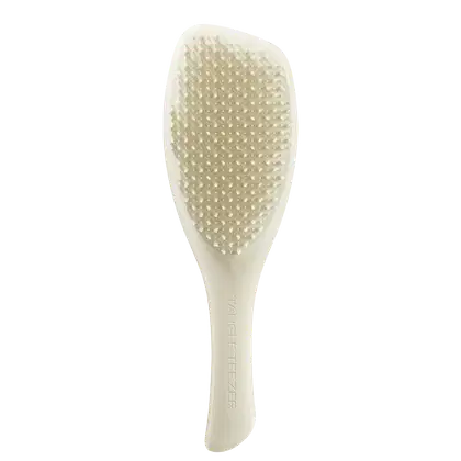 Escova de cabelo Tangle Teezer de cor branca, com superfície pontiaguda e texturizada, com o nome da marca impresso na lateral.