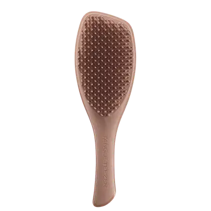Escova de cabelo Tangle Teezer de cor rosa clara, com superfície pontiaguda e texturizada, com o nome da marca impresso na lateral.
