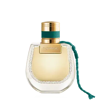 Frasco de perfume dourado com tampa e faixa verde, rótulo com a marca "NOMADE", embalagem de vidro com detalhes em relevo.
