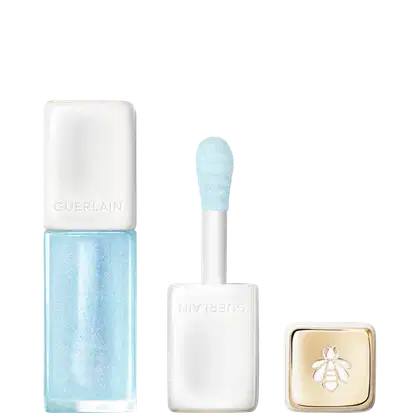 Lip oil da marca Guerlain em tom azul claro com aplicador em formato de esponja, acompanhado de caixa branca com logotipo dourado em forma de abelha.