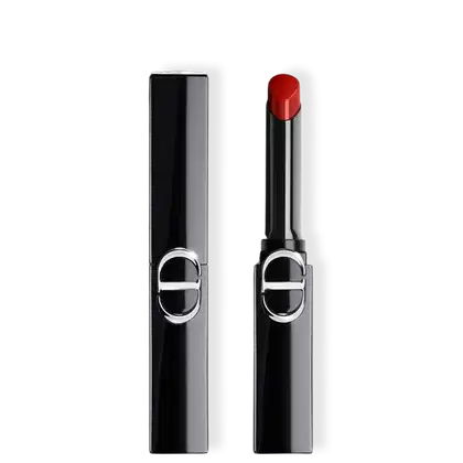 Batom Dior com embalagem preta e aplicador cilíndrico, exibindo cor vermelha intensa na ponta, com logo circular prateado na frente do tubo.
