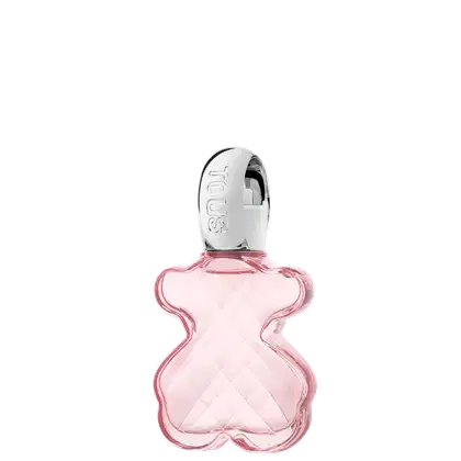 Frasco de item de perfumaria com formato curvilíneo em vidro rosa translúcido, com tampa prateada e rótulo com a marca "TOUS" em destaque.