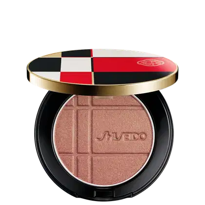 Pó Shiseido Color + Glow Enhancer  em embalagem redonda preta e dourada, com design xadrez em vermelho, branco e preto. O produto apresenta textura aveludada e logotipo da marca.