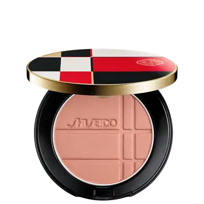 Pó Shiseido Color + Glow Enhancer  em embalagem redonda preta e dourada, com design xadrez em vermelho, branco e preto. O produto apresenta textura aveludada e logotipo da marca.