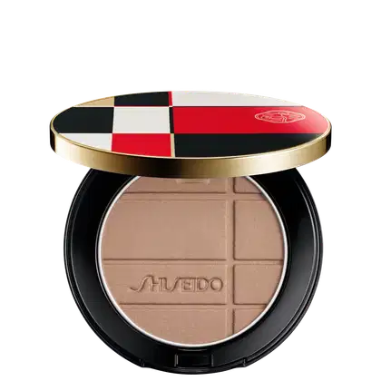 Pó Shiseido Color + Glow Enhancer  em embalagem redonda preta e dourada, com design xadrez em vermelho, branco e preto. O produto apresenta textura aveludada e logotipo da marca.