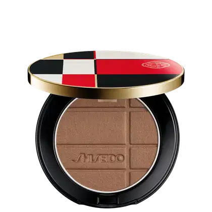 Pó Shiseido Color + Glow Enhancer  em embalagem redonda preta e dourada, com design xadrez em vermelho, branco e preto. O produto apresenta textura aveludada e logotipo da marca.