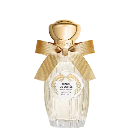Eau de Parfum Tenue de Soirée da Annick Goutal em frasco de cristal transparente com tampa dourada esférica. Apresenta laço de fita bege e rótulo circular branco com detalhes florais dourados.