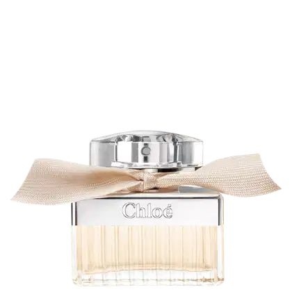 Frasco de perfume Chloé com tampa de metal e laço bege. Embalagem de vidro transparente com rótulo em relevo com o nome da marca. Produto de beleza com design elegante e sofisticado.