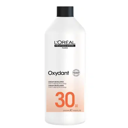 Frasco branco da linha Oxydant da L'Oréal Professionnel, com rótulo preto e laranja, contendo 1000ml de creme revelador com tecnologia de bloqueio de odor, com concentração de 30 volumes.