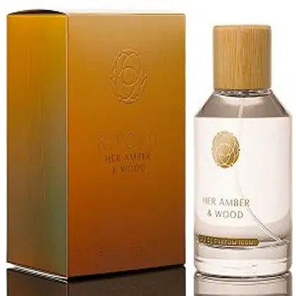 Caixa dourada e frasco de perfume da linha Her Amber & Wood da marca Kiyomi, com rótulo em branco e detalhes dourados.