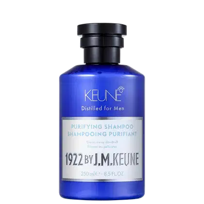 Shampoo em um frasco é azul translúcido, permitindo ver o líquido de cor azul vibrante dentro. A embalagem tem uma tampa preta e apresenta o nome da marca Keune, o nome da linha Distilled for Men e a descrição "Purifying Shampoo" em letras brancas.