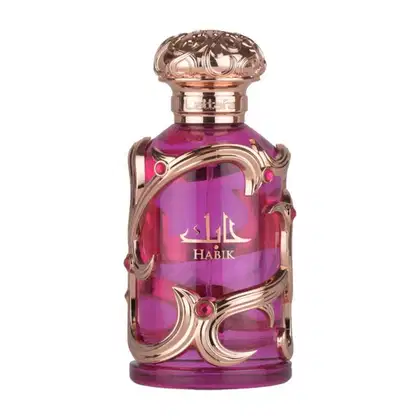 Frasco de perfume Lattafa Habik, com design ornamentado em tons de rosa e dourado, contendo líquido de cor roxa vibrante. O rótulo exibe o nome "Habik" em árabe e letras douradas.