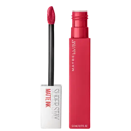Tubo rosa vibrante com o nome da marca "Maybelline New York" impresso. Ao lado, um aplicador preto com uma ponta esponjosa em formato de lágrima.