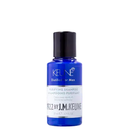 Shampoo em um frasco é azul translúcido, permitindo ver o líquido de cor azul vibrante dentro. A embalagem tem uma tampa preta e apresenta o nome da marca Keune, o nome da linha Distilled for Men e a descrição "Purifying Shampoo" em letras brancas.