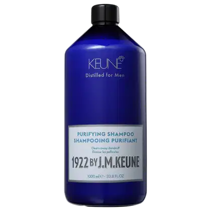 Shampoo em um frasco é azul translúcido, permitindo ver o líquido de cor azul vibrante dentro. A embalagem tem uma tampa preta e apresenta o nome da marca Keune, o nome da linha Distilled for Men e a descrição "Purifying Shampoo" em letras brancas.