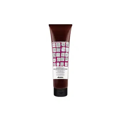 Tubo de condicionador Davines Replumping, com embalagem marrom escura e rótulo com padrão de flores brancas. O produto é destinado a cabelos, com foco em volume e hidratação.