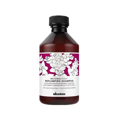 Frasco de shampoo Davines Naturaltech Replumping, com rótulo em fundo roxo e flores brancas, contendo 250ml do produto.