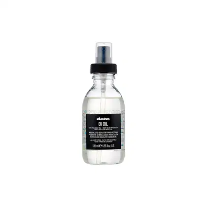 Frasco de vidro transparente com spray preto contendo óleo de beleza Davines Oi Oil. Rótulo preto com texto branco indicando o nome do produto e informações sobre seu uso em diferentes tipos de cabelo.
