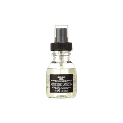 Frasco de spray transparente com rótulo preto da marca Davines contendo um produto de beleza chamado "Absolute Beautifying Potion", indicado para todos os tipos de cabelo.