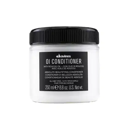 Frasco de condicionador Davines OI com 250 ml, embalagem branca e preta com rótulo destacando o nome do produto e a presença de óleo de roucou, indicado para todos os tipos de cabelo.