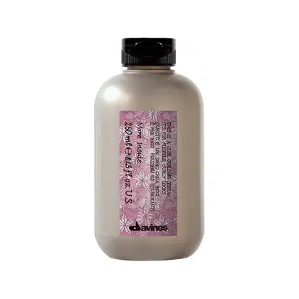 Frasco de produto de beleza da marca Davines, com rótulo rosa e branco, contendo informações sobre o produto. O recipiente é de plástico transparente com tampa preta.