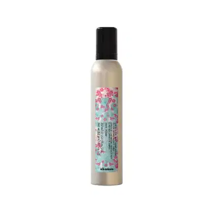 Frasco de spray com rótulo rosa e azul da marca Davines. O produto é um spray para cabelos, com informações sobre sua composição e uso impressas no rótulo.