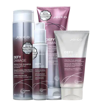 Produtos da linha Defy Damage da Joico, incluindo shampoo protetor, condicionador protetor e máscara protetora, em embalagens de plástico branco e rosa com detalhes em prata.