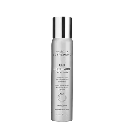 Frasco de névoa celular da marca Institut Esthederm Paris, com design elegante em tons de branco e prata. O rótulo destaca o nome "Eau Cellulaire" e menciona os benefícios de hidratação e ação antioxidante do produto.