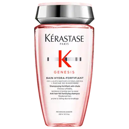 Frasco de shampoo da marca Kérastase Paris, da linha Genesis, com embalagem rosa e prata. O rótulo apresenta o nome da marca, da linha e informações sobre o produto, que é um shampoo fortificante anti-queda.