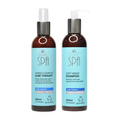 Dois frascos de produtos de cabelo da marca Grandha: um frasco de 250ml de Terapia Capilar com Complexo de Aminoácidos e outro frasco de 250ml de Shampoo Soft Mind, ambos com rótulos em tons de azul e marrom.