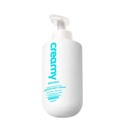 Frasco branco com bomba de 200ml contendo creme corporal da marca Creamy Skincare, com rótulo em azul turquesa exibindo o nome da marca e a descrição "Ceramide Body Cream".