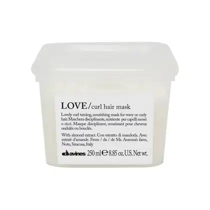 Embalagem plástica branca com rótulo preto e branco contendo a descrição "LOVE/curl hair mask" da marca Davines. O produto é apresentado como uma máscara nutritiva para cabelos ondulados ou cacheados, com extrato de amêndoa.